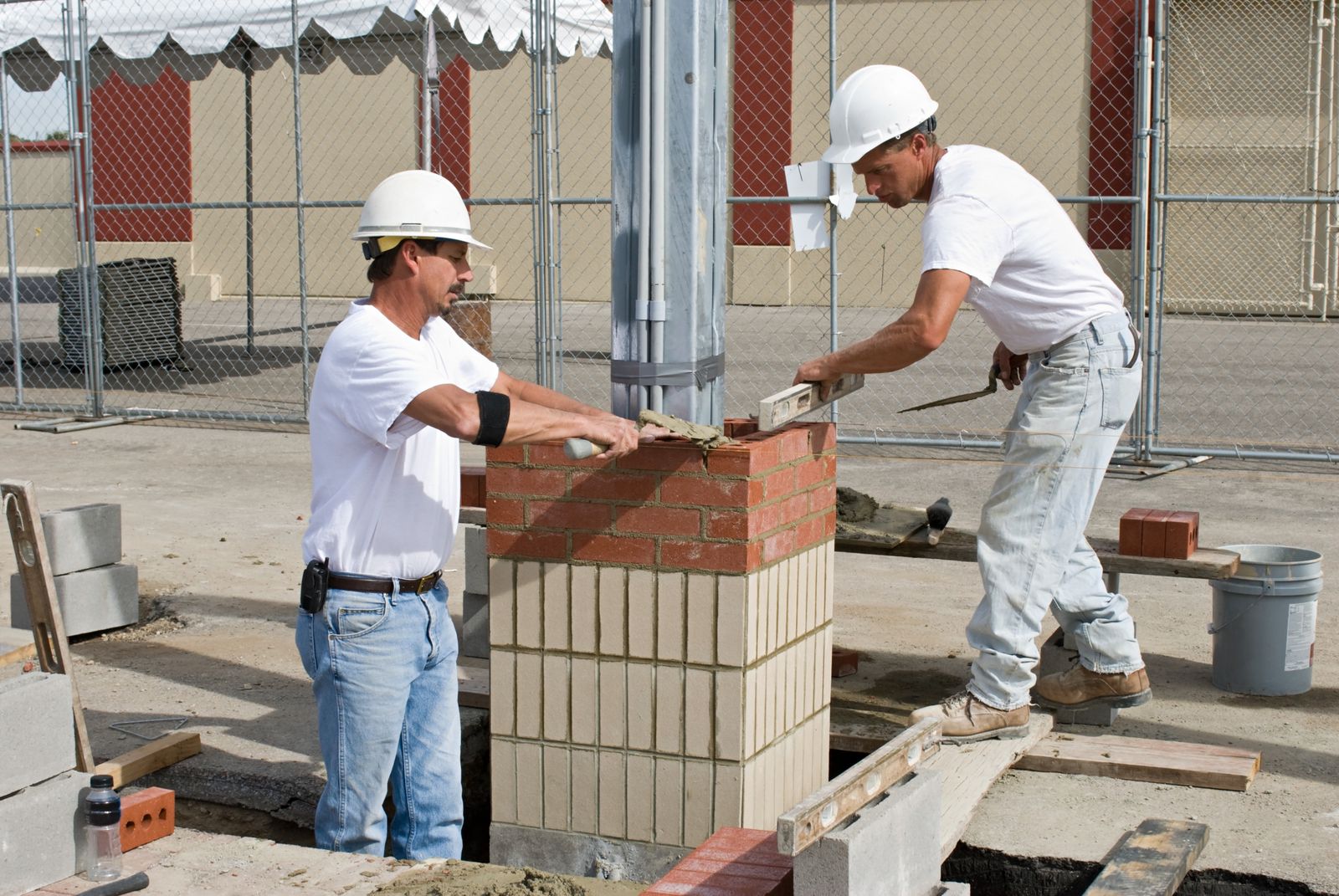 Two masons laying brick on a wall in Chicago